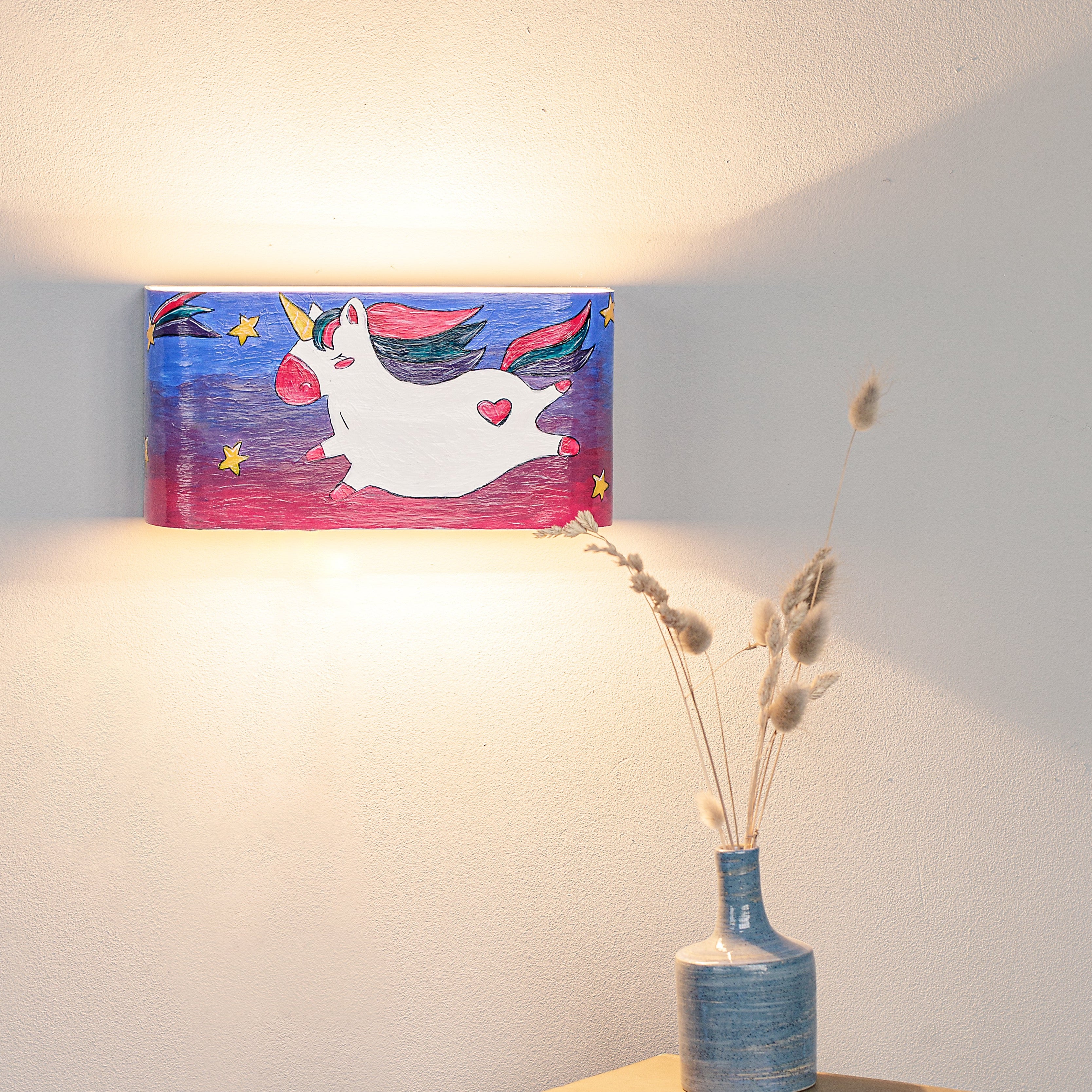 Hand-painted unicorn nursery wall sconce mounted on a wall