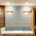 Set of 2 ash 3-light wall sconces on a wall