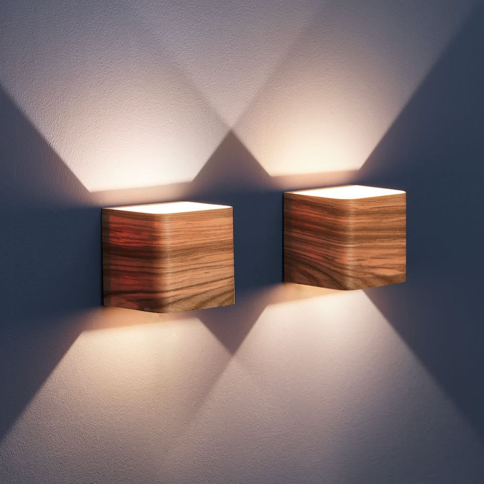 Pair of ash bedside wall lamps mounted by a bed