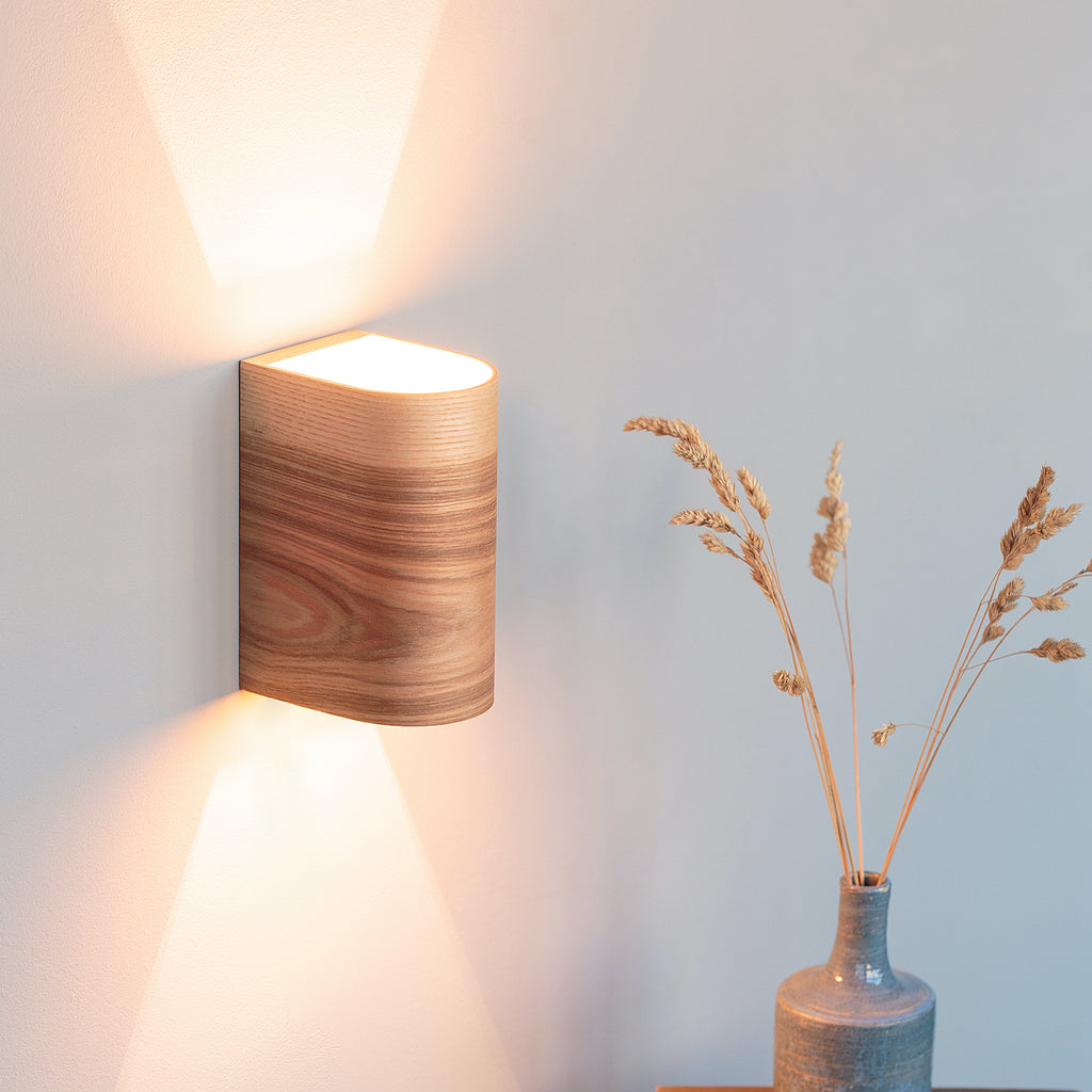 Ash wood wall sconce mounted on a bedroom wall