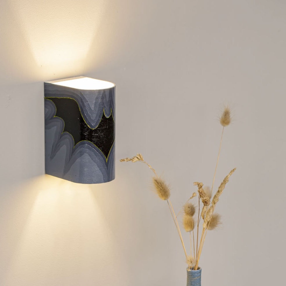 Hand-painted decorative wall sconce mounted on a wall