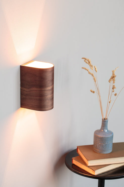 Black walnut wood wall sconce mounted on a wall